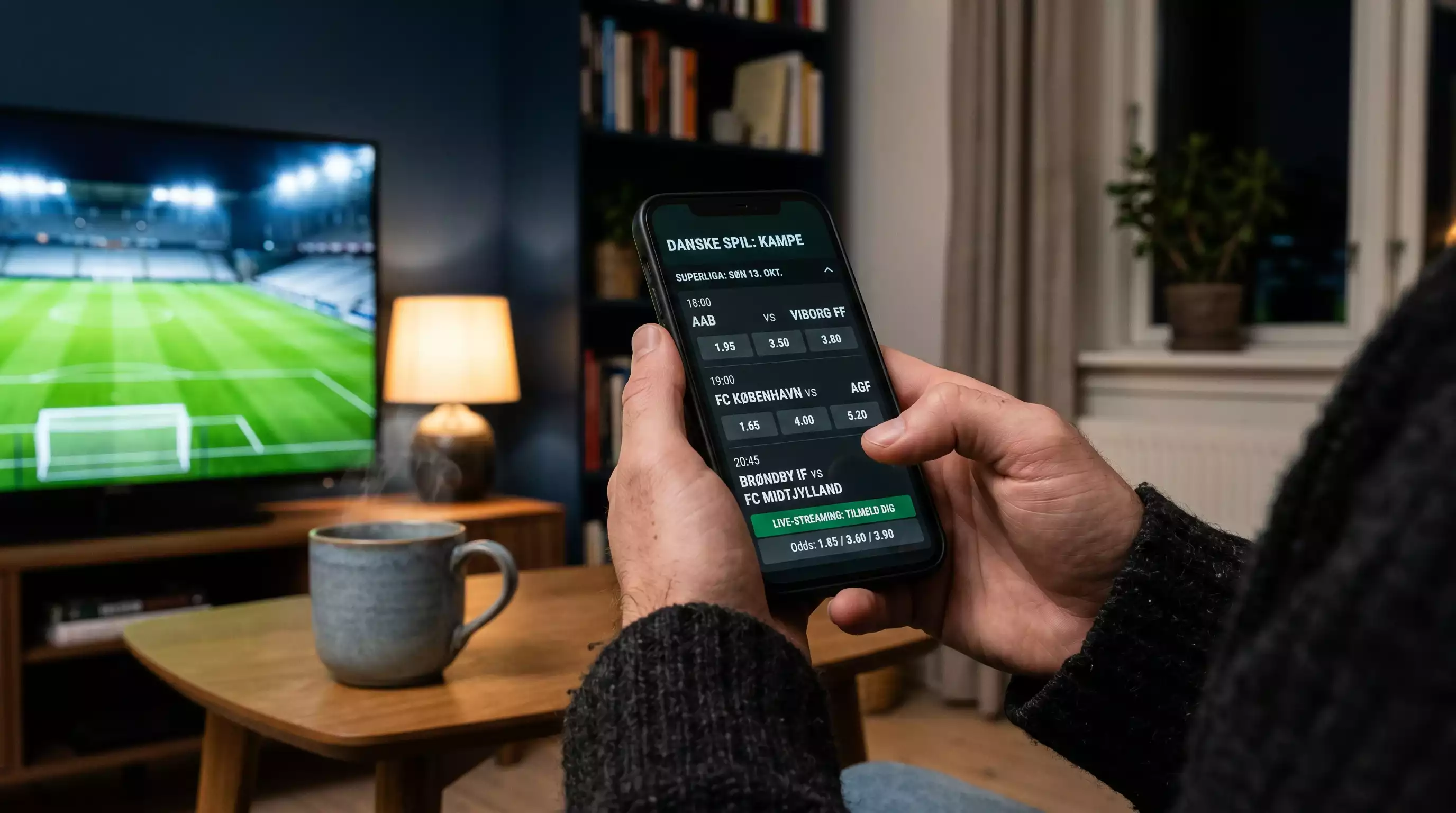 Dansk fodboldfan følger Superliga-kamp via mobilapp fra licenshavende bookmaker