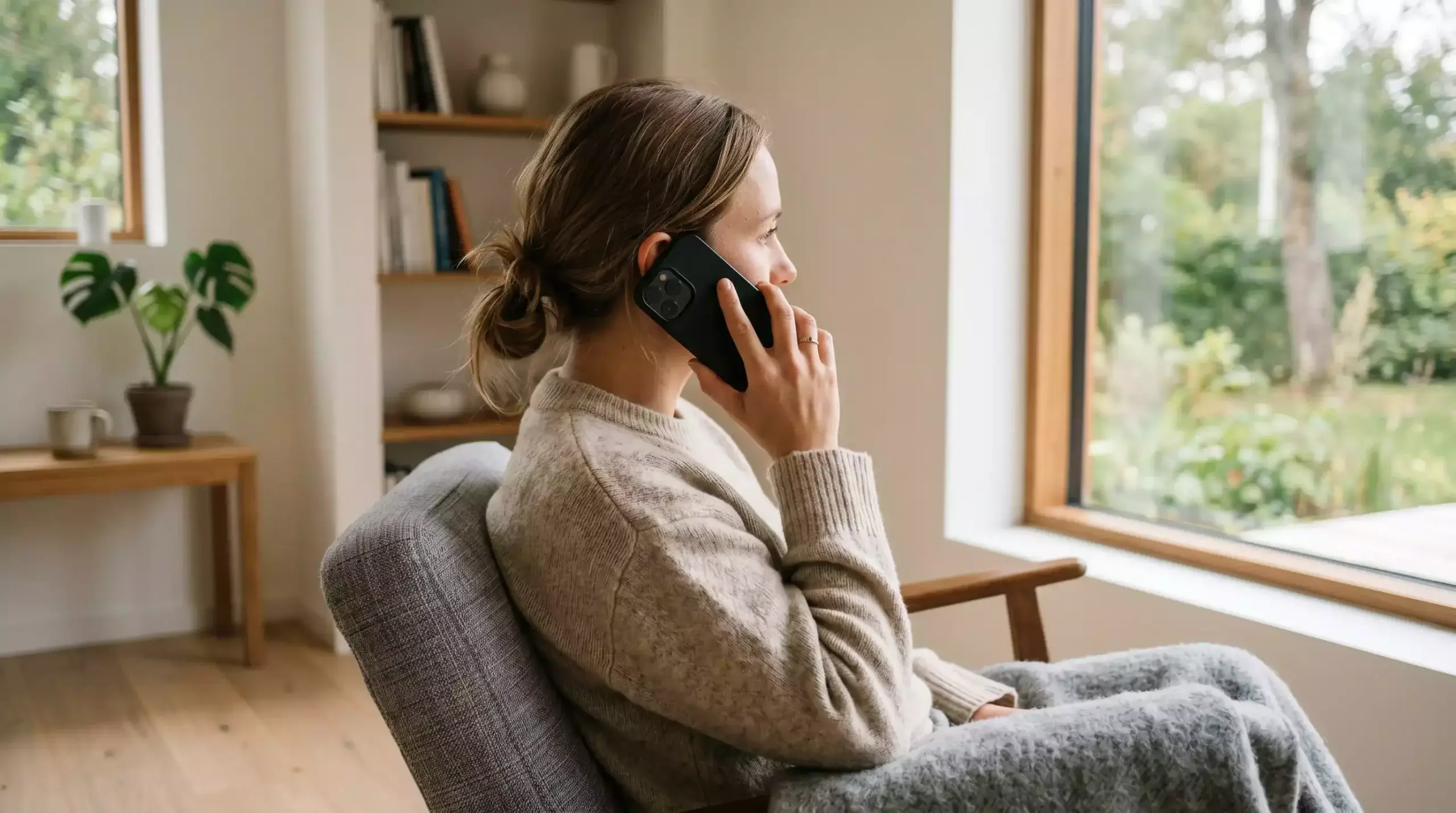 Person med mobiltelefon og hjælpelinje-kontaktskærm i dansk format
