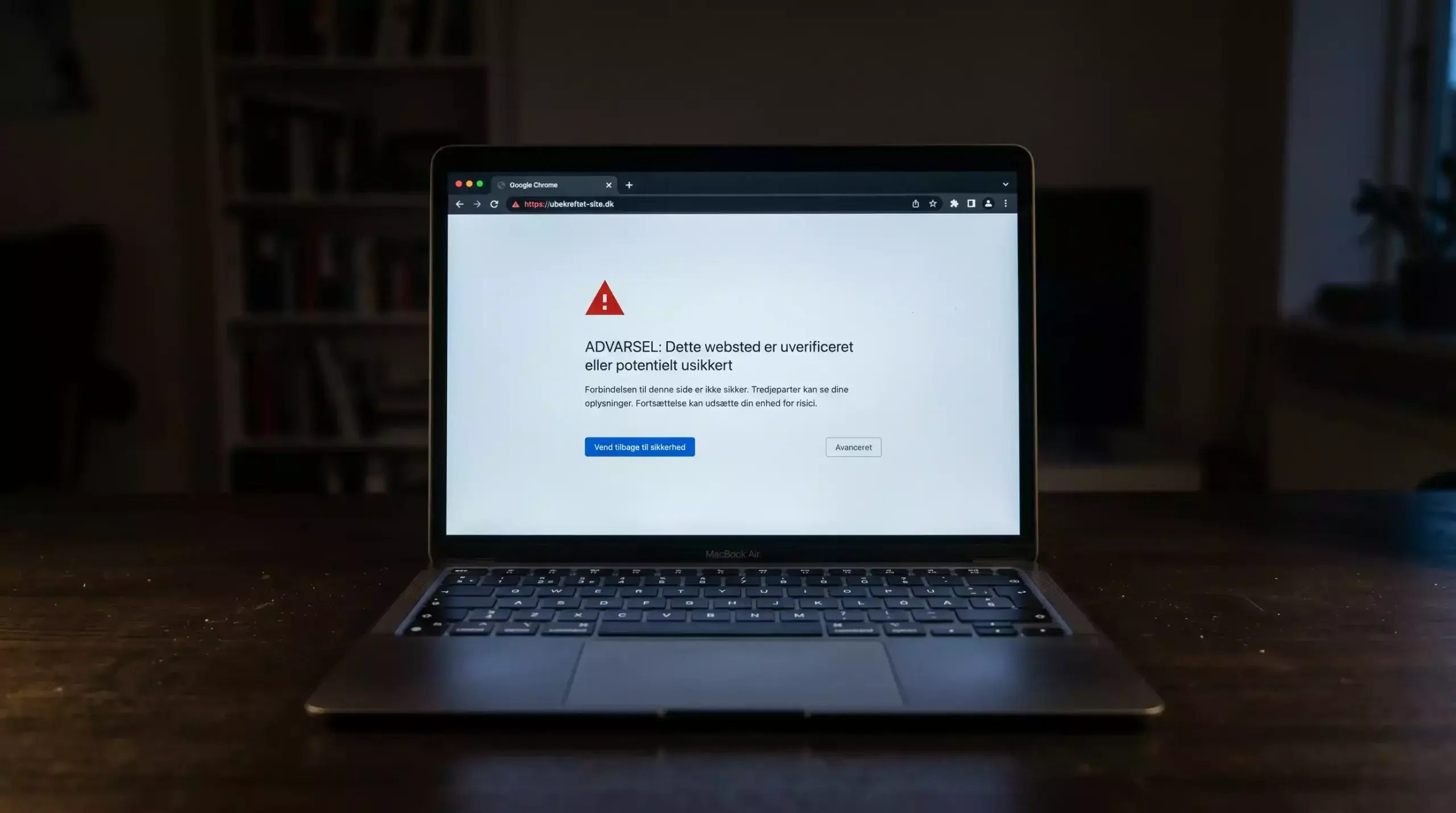Laptop med advarselsskilt og ukendt spilside uden dansk licens