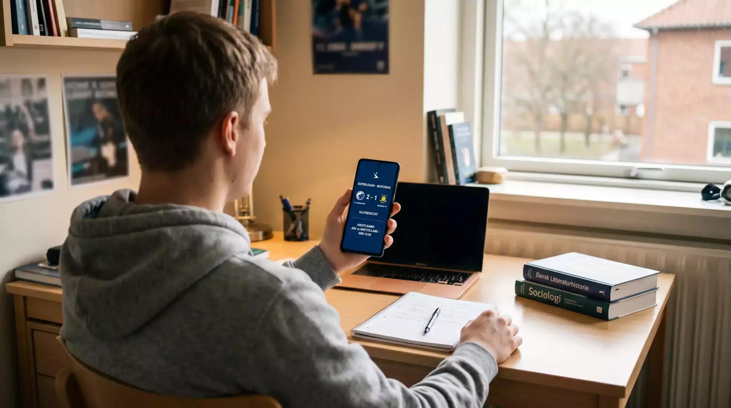 Ung person med smartphone og spilreklame i studiemiljø
